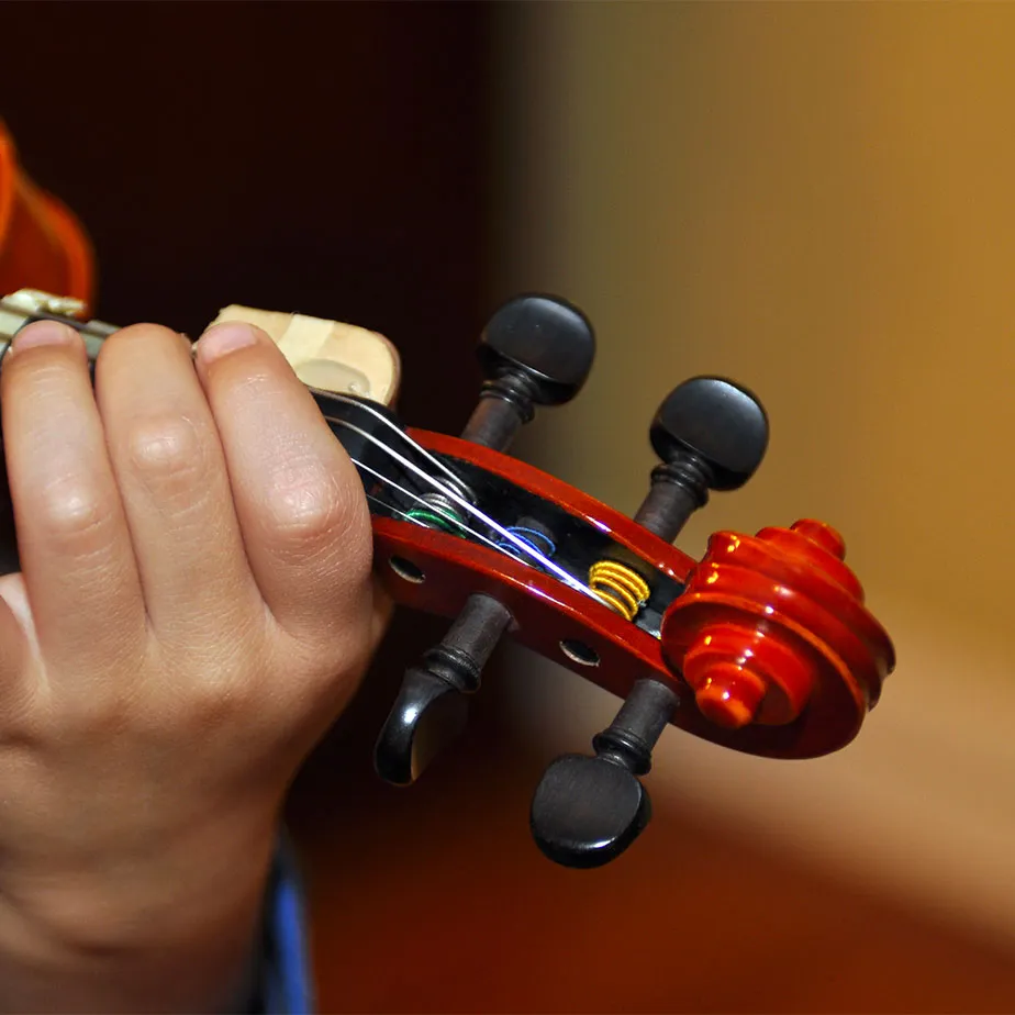 Closeup cropping of a child's hand playing a violin